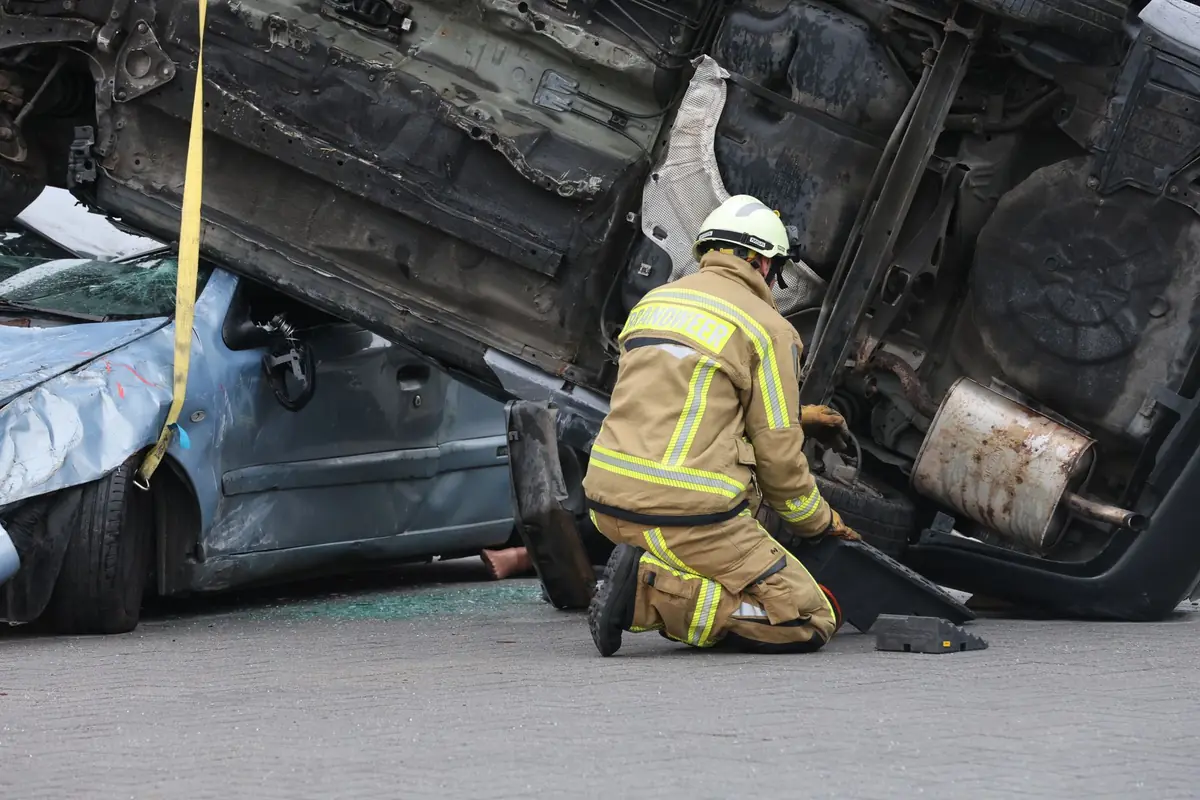 Abogado de accidentes de auto en San Antonio: un bombero trabajando junto a un auto volcado tras una colisión