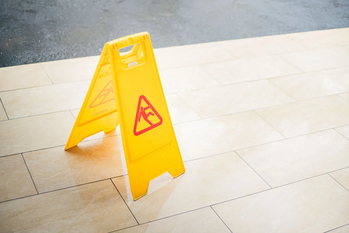 Richardson premises liability lawyer: a yellow wet floor warning sign on a tiled floor